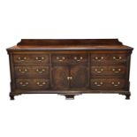 An impressive George III mahogany dresser base Having a rectangular moulded and crossbanded top