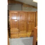 A modern pine triple wardrobe Having a moulded cornice above an arrangement of two long panelled