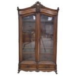 An impressive walnut French style display cabinet, 19th Century The arched pediment with a leafy C