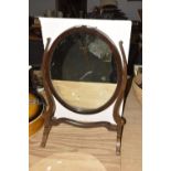 An early 20th Century mahogany toilet mirror The oval plate supported on two curvilinear uprights