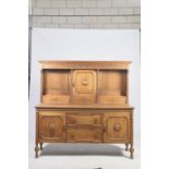 A 1920's honey oak Jacobean revival dresser Having a molded cornice above a scrolling leaf carved