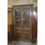 A mid 20th Century oak Priory style glazed bookcase Having two leaded glazed doors above two linen