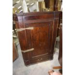 A George III oak and mahogany crossbanded hanging corner cupboard Having a moulded cornice above a