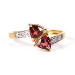 A garnet and diamond dress ring Of crossover design, the triangular shape garnet terminals with