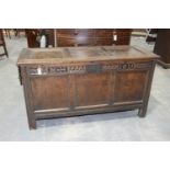 A 17th Century oak coffer Having an inverted moulded three panel top above a frieze carved with an