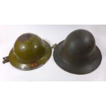 Two British steel helmets, mid 20th Century The first Brodie helmet pale green numbers in red 22,