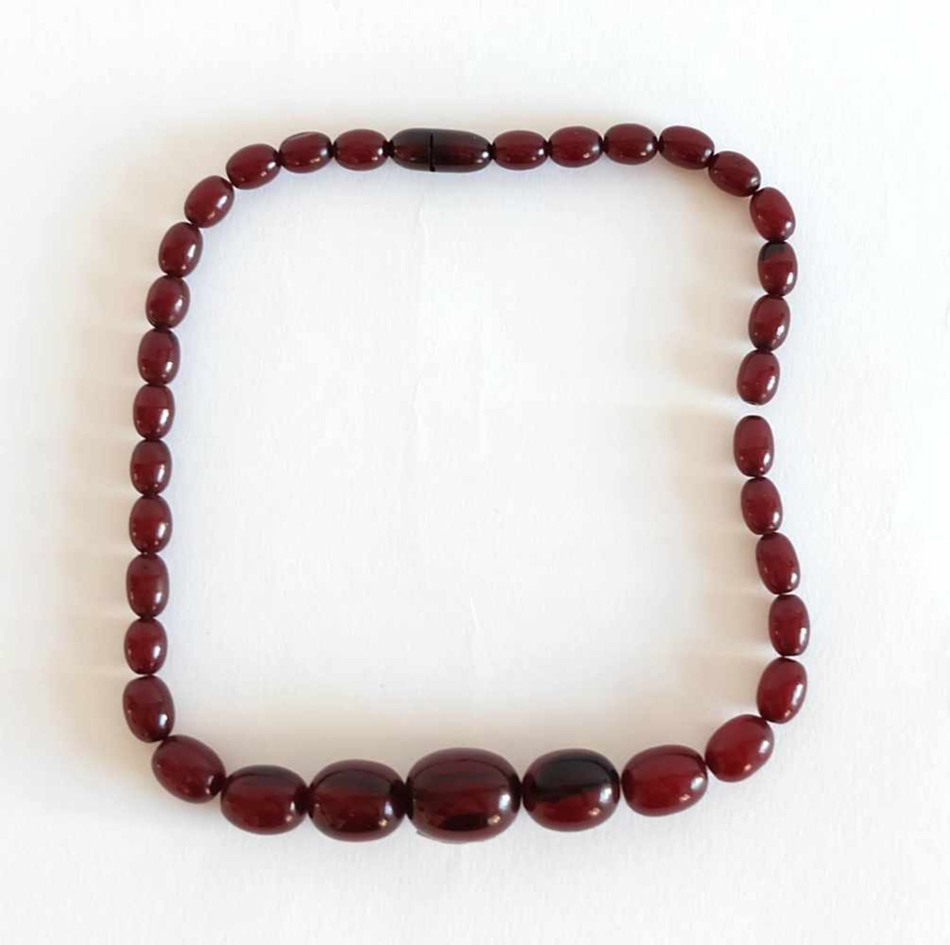 COLLIER, 1930er-/ 40er-Jahre, Cherry-Bernstein, verlaufende Oliven, Schraubverschluß, ca. 30g, L