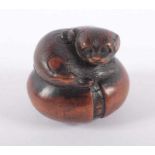 NETSUKE WELPE AUF KEMARI, Buchsbaum, fein geschnitzt und graviert, L 3,8, sign. Masatomo Provenienz: