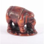 NETSUKE STEHENDER ELEFANT, Holz, fein geschnitzt und graviert, das kräftige Tier trägt eine mit