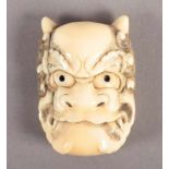 MASKEN-NETSUKE ONI, maritimes Elfenbein, fein graviert und dunkel akzentuiert, H 5,8, JAPAN, um 1900