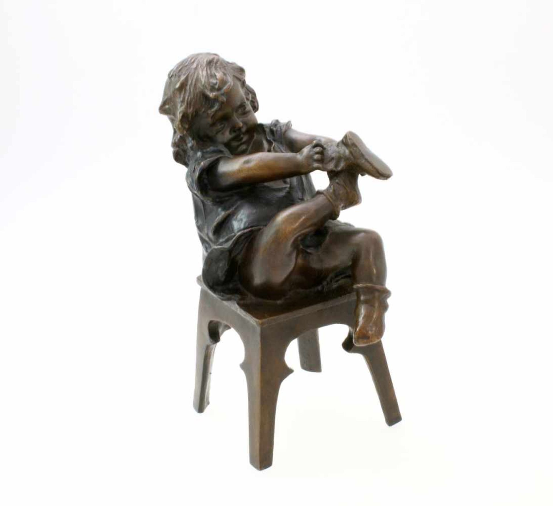 Bronzeskulptur "Kleines Mädchen beim Schuh anziehen" von Juan Clara Ayats (1875 - 1958) Die Skulptur
