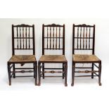 A set of six early 19th century ash and elm spindle back rush seated dining chairs,