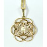 A 9ct yellow gold stylised pendant set with a central cultured freshwater pearl on a 9ct yellow