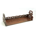 A Victorian rosewood book trough with pierced shaped ends and shaped pierced back rail with simple