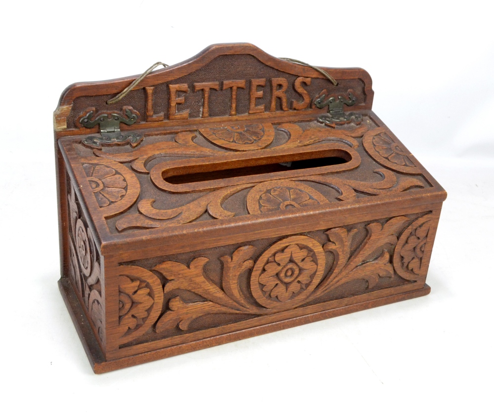 A late Victorian carved oak wall mounted letter box, the shaped back rail inscribed 'Letters',