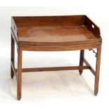 A mahogany bowfronted side table modelled as a butler's tray with fixed 'tray top' above chamfered
