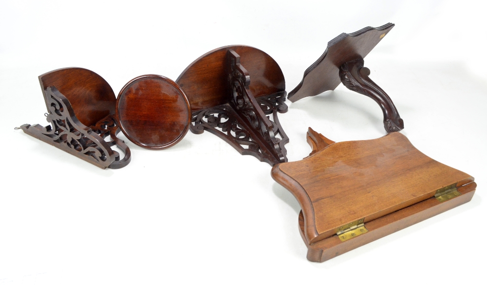 Five wall brackets, including a shaped walnut example with hinged platform and bracket support,