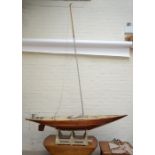 A large vintage pond yacht with rudder, sails and scratch built stand, length of hull approx 200cm.