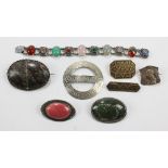 A group of brooches to include two polished stone examples,