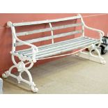 A white painted cast iron garden bench with later wooden slats, width approx 180cm.