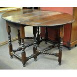 An 18th century oak drop leaf gateleg dining table raised on block and turned supports, height 77cm,