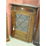 A late George III oak flat fronted corner cupboard with three quarter glazed and quarter panelled