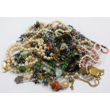 A mixed lot of costume jewellery including faux pearl and bead necklaces, enamelled brooches,