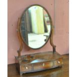 A George IV mahogany swing toilet mirror with oval plate above bowfronted base set with three
