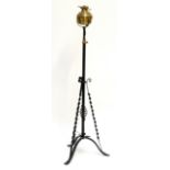 A brass and wrought iron adjustable oil lamp converted to electricity,