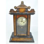 A thirty hour inlaid mantel clock with carved pediment on rectangular base,