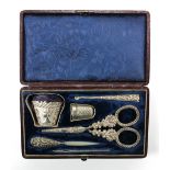 A cased Victorian white and base metal sewing set including a bucket shaped pin cushion decorated