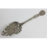 A Middle Eastern silver cake server with pierced and cast foliate scroll motifs,