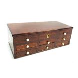 A mahogany and inlaid travelling cabinet with hinged lid above six small drawers flanked by