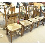 A set of four ash and elm spindle back rush seated dining chairs raised on turned front legs to pad