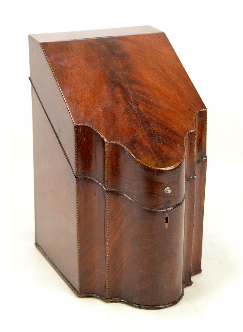 A George III mahogany and chevron strung knife box of serpentine outline with hinged lid,