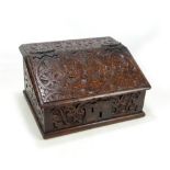 A late 17th century oak bible box with later carving and hinged lid enclosing five apertures above