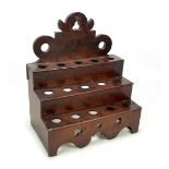 A George III oak spoon rack with shaped pierced back above three steps,