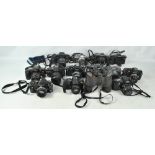 A group of cameras and lenses including Nikon F-301 and F-501, Pentax P30N and SFX, Canon EOS 650,