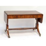 A mahogany crossbanded two drawer sofa table with brass paw feet to castors,