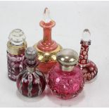 Five various scent bottles to include a hallmarked silver mounted cranberry hobnail cut glass