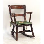 A 19th century child's beech and elm bar back elbow rocking chair.