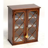 An Edwardian mahogany and satinwood detailed twin door glazed hanging wall mounted cabinet,