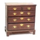 A George III oak chest of two short and three long graduated drawers raised on bracket feet,