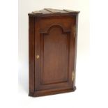 A George III oak flat fronted corner cupboard with fielded panel door, height 90cm.