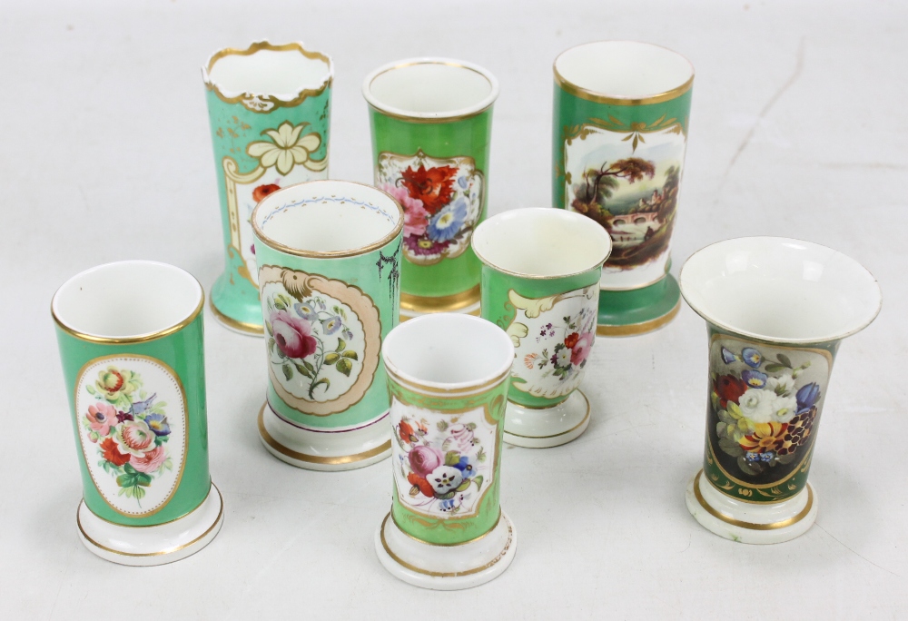 Seven Coalport floral painted green ground gilt heightened spill vases and a similar Bloor Derby