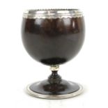 An early 19th century Colonial white metal mounted coconut goblet with waisted stem above domed