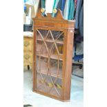 A mahogany wall cabinet with broken swan neck pediment above glazed door enclosing three shelves,