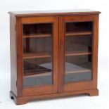 A freestanding mahogany bookcase with twin glazed doors enclosing three shelves, 119.5cm x 111cm