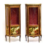 A pair of 20th century French vitrines of serpentine form, each with elaborate applied gilt metal