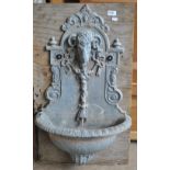A 20th century lead wall mounted fountain centred with a ram's head decorated with swags and